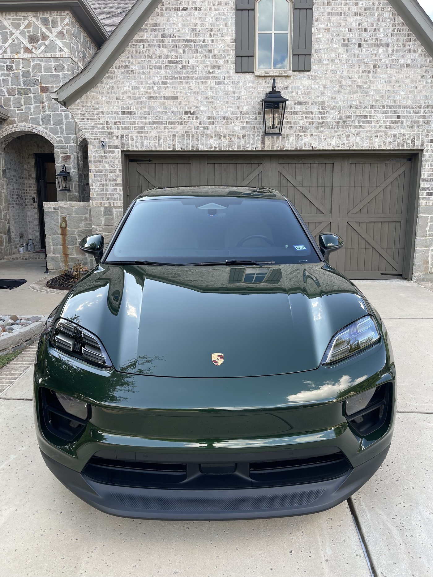 Dark green Porsche Macan Electric with a glossy ceramic coated finish