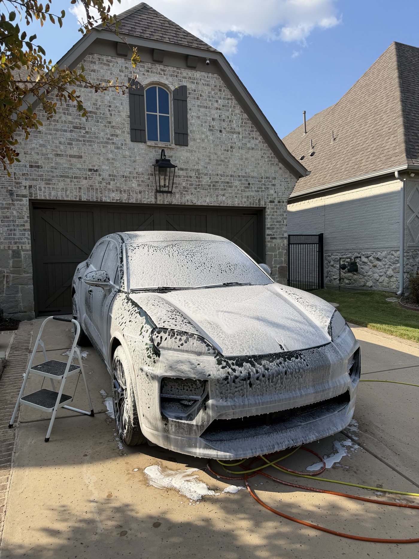 Freshly washed white Porsche Macan on a maintenance detailing plan